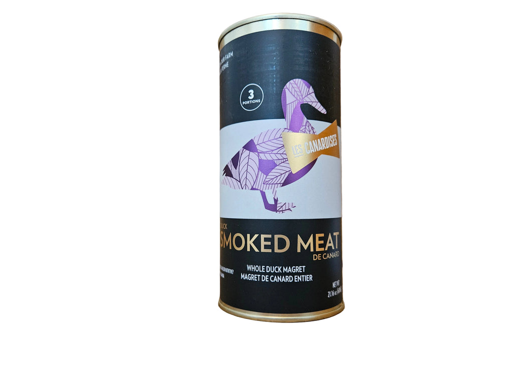 A cylindrical metal can of Duck Hunter Smoked Meat de Canadair, featuring a black and white label with a purple and gold duck illustration, set on a wooden surface.